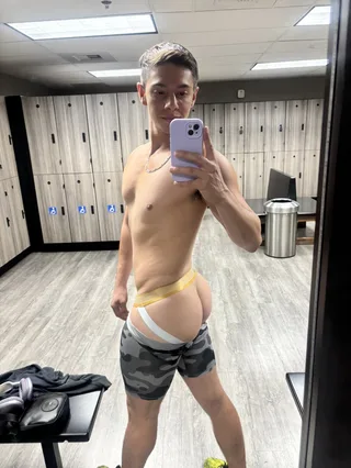 Ginástica twink selfie exibindo shorts de camo apertado e tanga atrevida espiando no espelho do vestiário