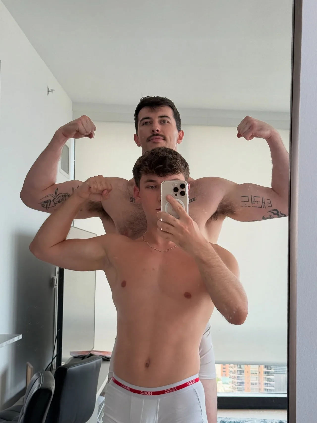 Two hot guys flexing shirtless in their underwear for a mirror selfie at home - photo 2