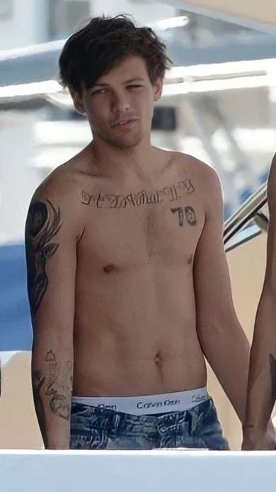 Skjult Louis Tomlinson flaunts tatoveret torso og Calvin Klein talje ved vandet