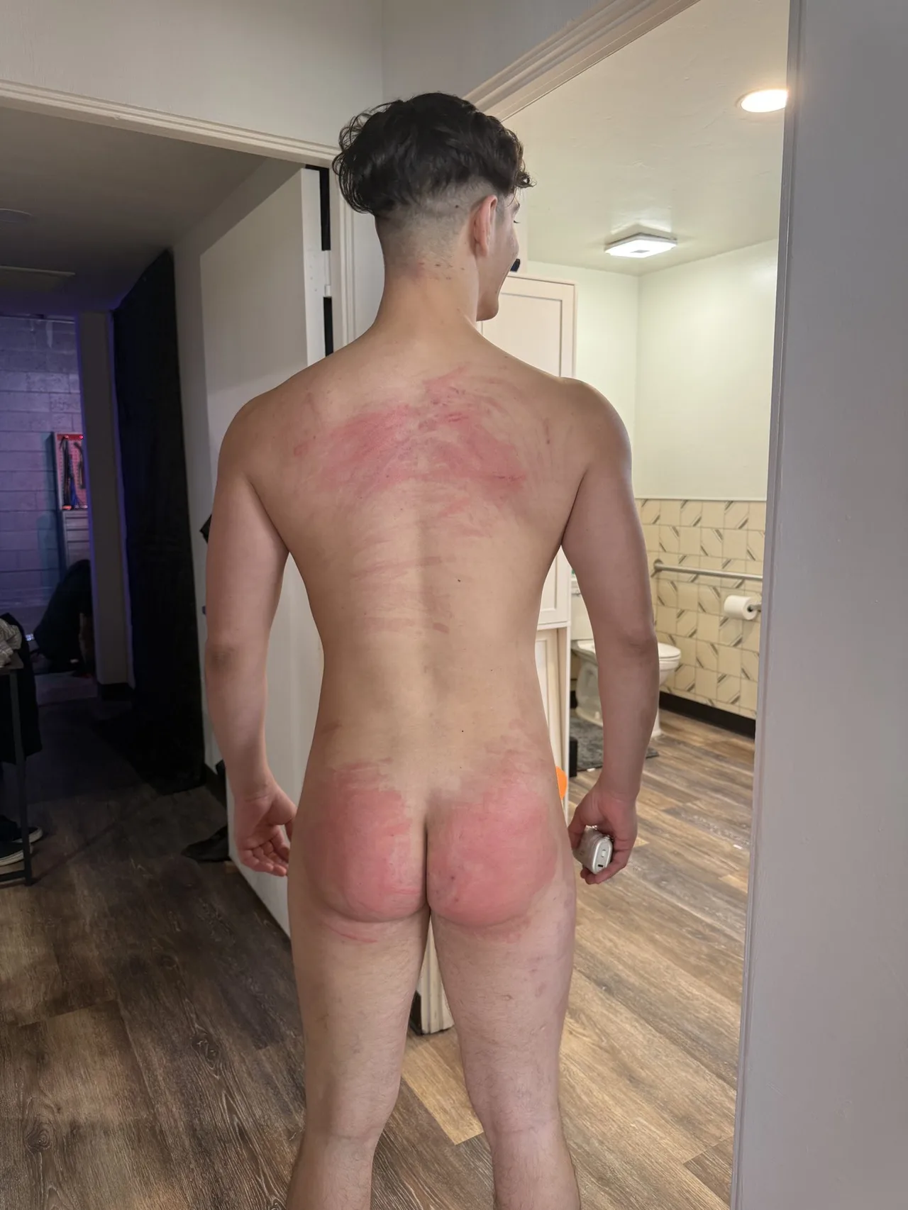 Uartige dreng viser sin røde røv og tilbage i et dampet badeværelse spejl selfie