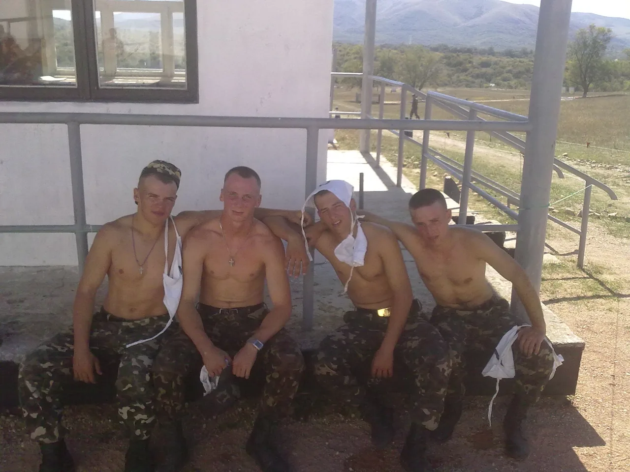 Fire shirtless military- stil fyre i camo bukser udgør bare- chested med hvide underskjorter hængende løs