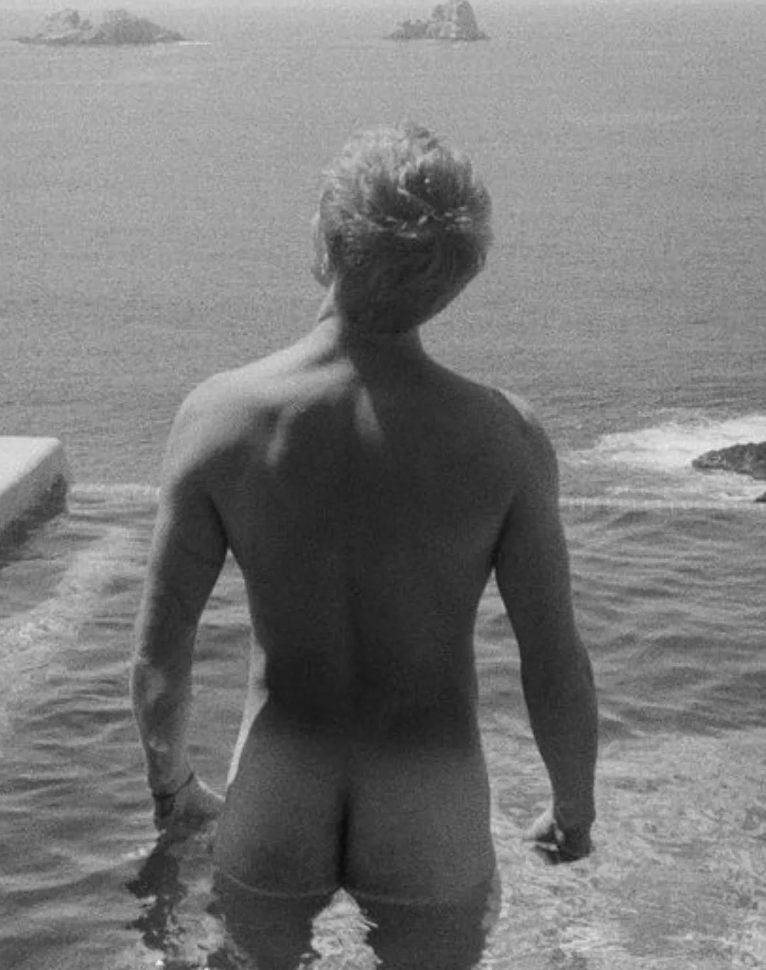 Hart Denton naked from behind gazing at the ocean waves