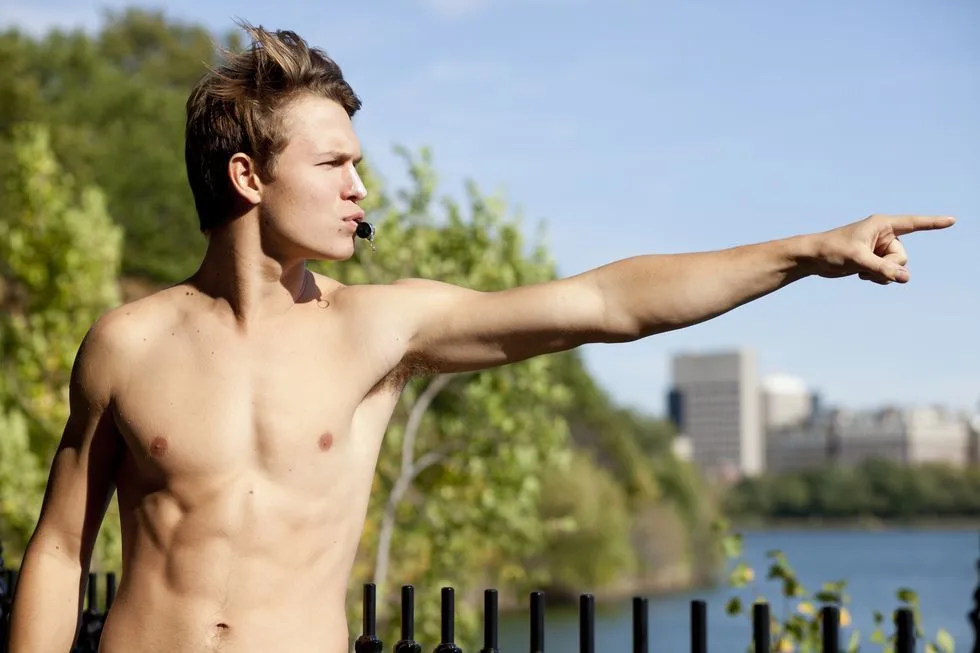 Skjult Ansel Elgort peger med skulpturelle abs og solkysset hud udendørs