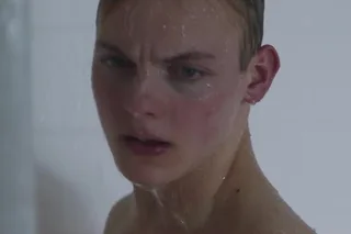 David Pulsers sem camisa sob banho spray com olhar intenso