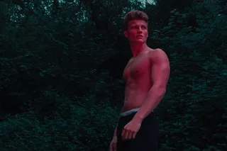 O torso cinzelado de Zach Hartman brilha sob a luz da floresta, sem camisa e confiante em calções de Calvin Klein