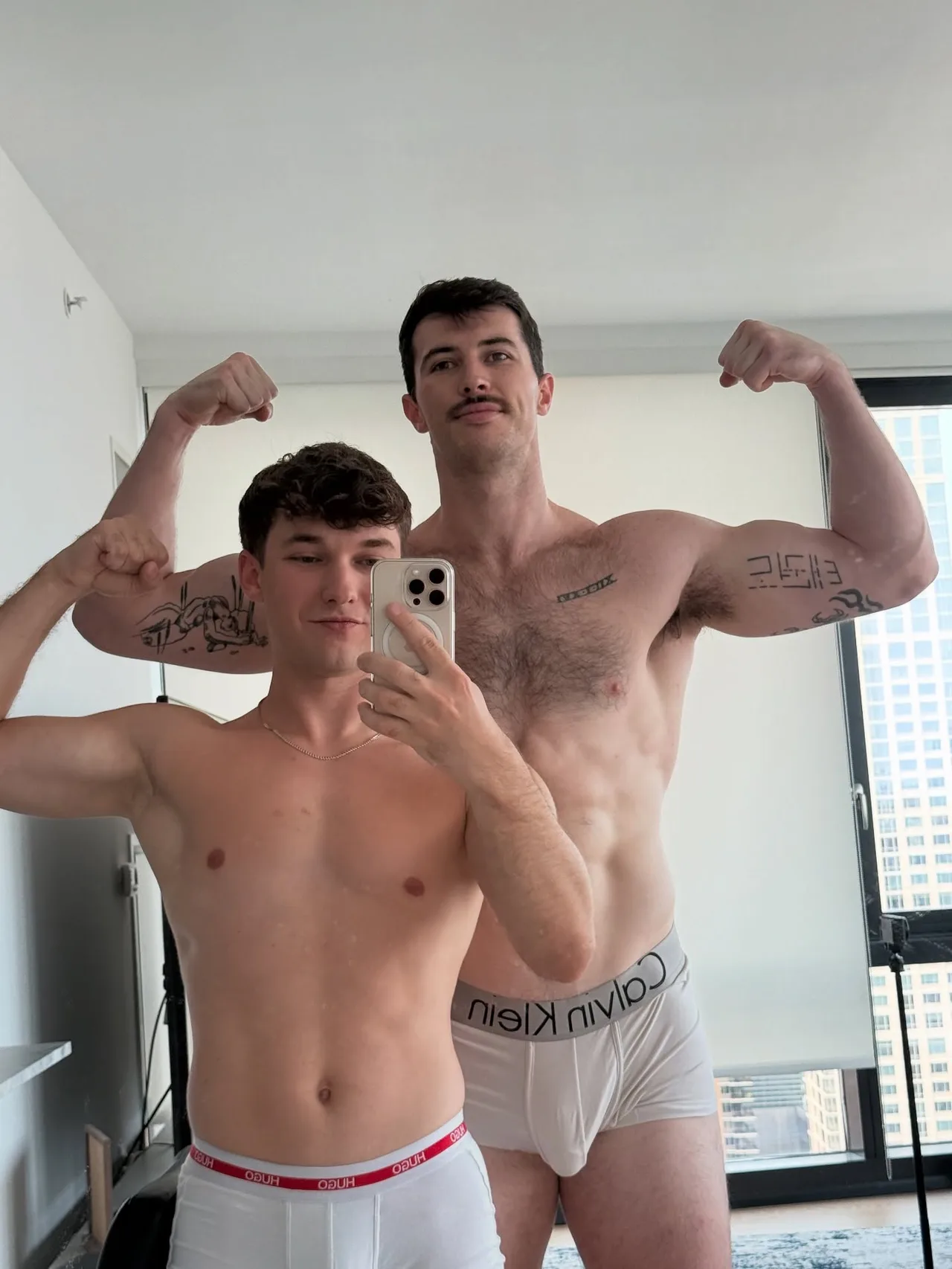 Two hot guys flexing shirtless in their underwear for a mirror selfie at home - photo 4