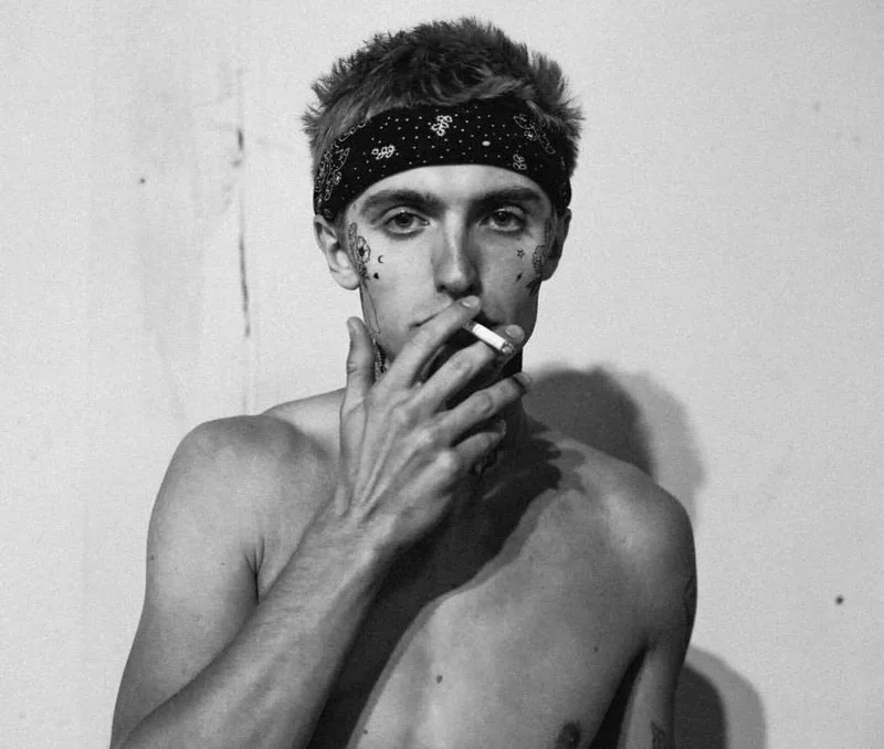 Hart Denton shirtless with bandana and smoky gaze in moody black and white