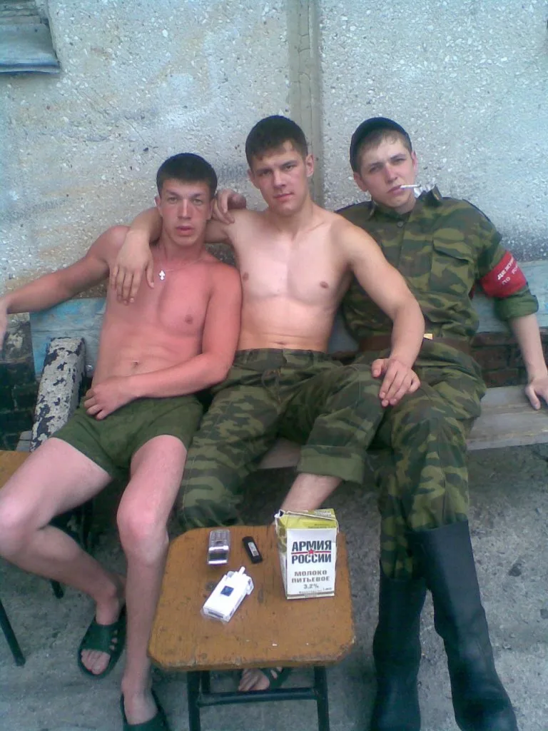 Tre hot military- stil fyre lounging shirtless med camo bukser og støvler, en rygning