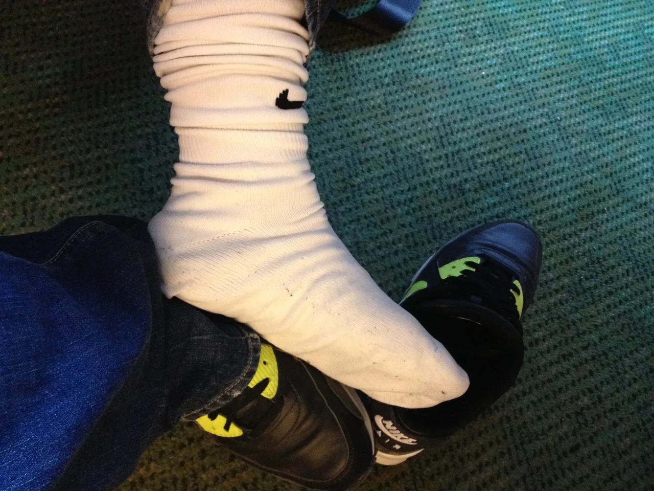 Cara de meias brancas Nike e tênis pretos brincando com fetiche por pés com pernas de ganga