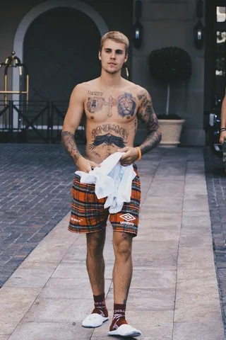 Justin Bieber Camisa Sem Camisa em Calções xadrez segurando uma toalha ao ar livre