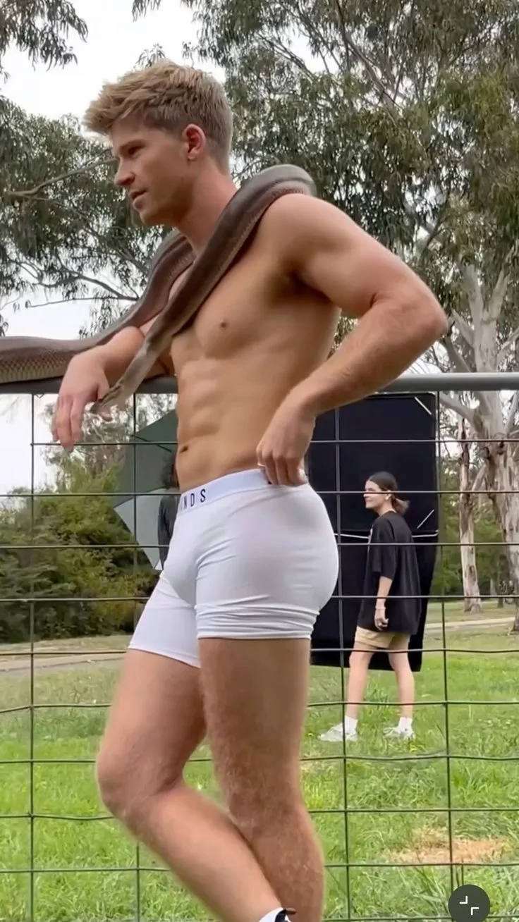 Robert Irwin sin camisa con una serpiente envolvida sobre sus hombros en calzoncillos blancos