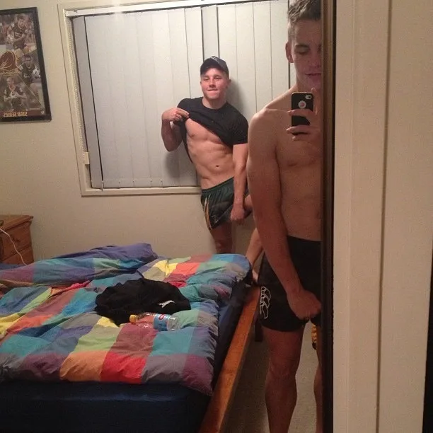 To lækre heteroseksuelle fyre, der spiller shirtless i soveværelsesspejl, en løfter tee for mavemuskler, en i små sorte kufferter