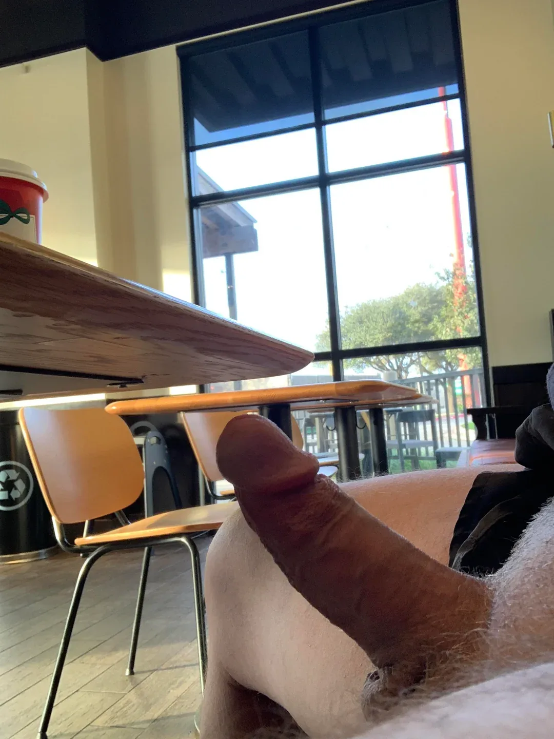 Pau duro em exibição completa sob mesa de café, cara posando com pelos pubianos e bolas à mostra