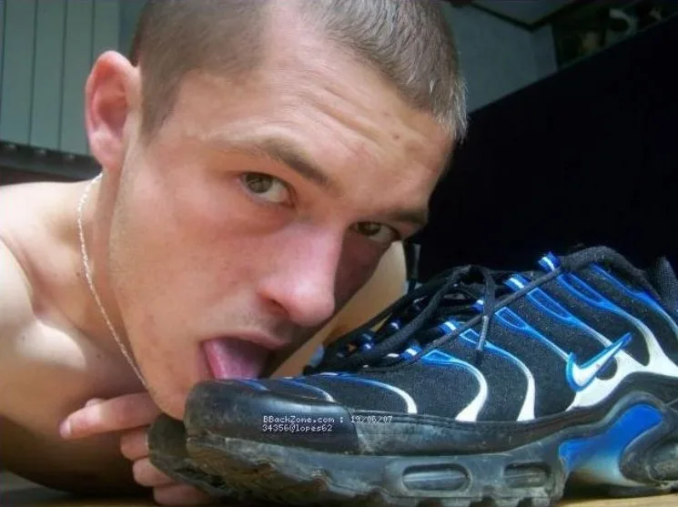 Skjoldløs dreng slikker beskidt sneaker sål med tunge ud, intens fod fetich close- up