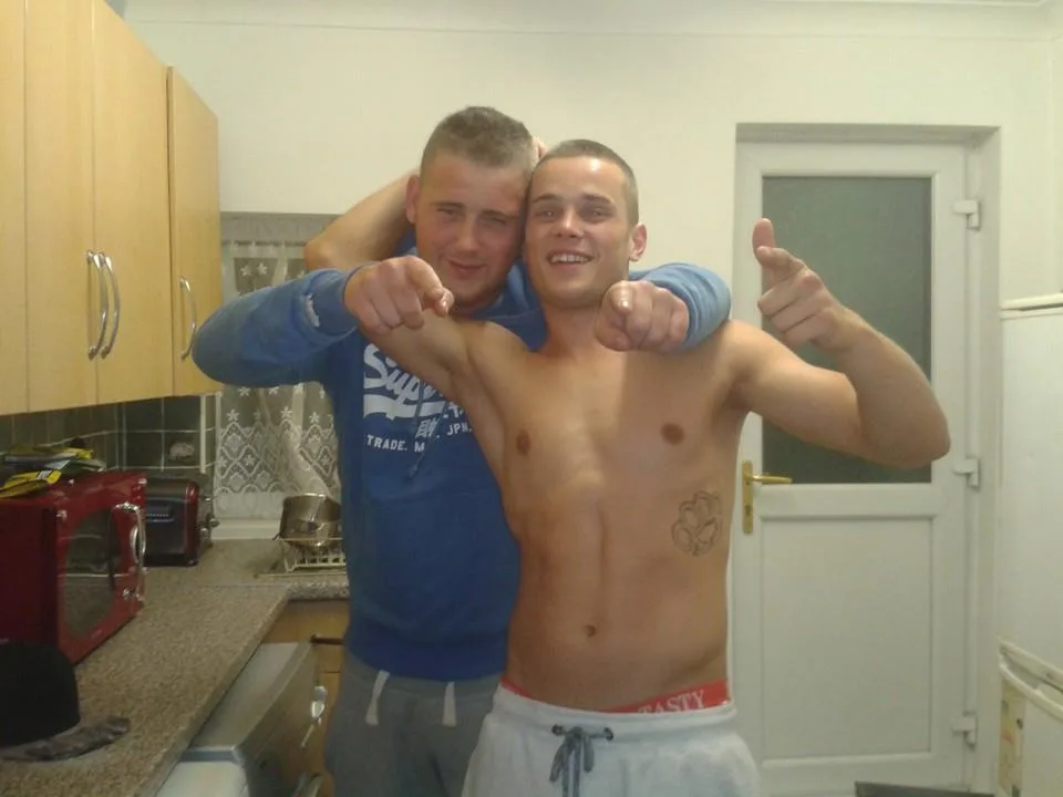 Twee brutale jongens in de keuken, één shirt zonder boxershorts, zowel grijnzend als wijzend naar jou