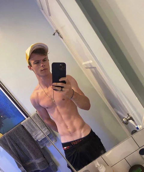 Shirtless guy in boxer briefs takes mirror selfie, feet hidden but abs on display