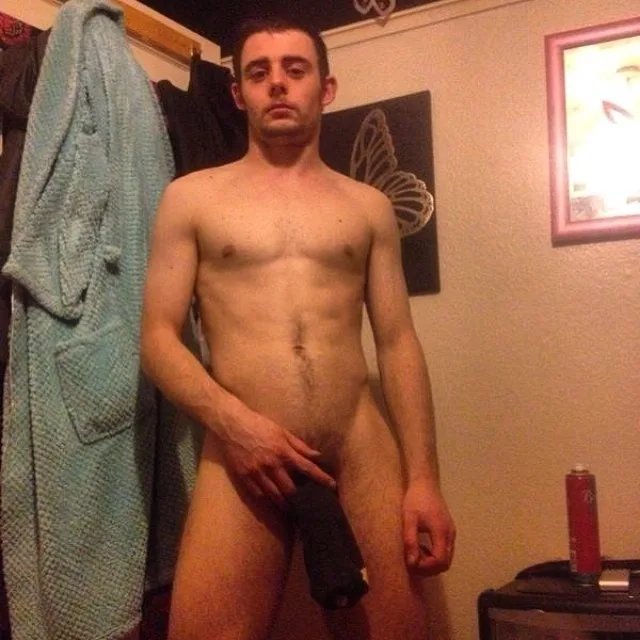 Homem com pênis ereto segurando sua própria cueca preta em um quarto, nu frontal completo