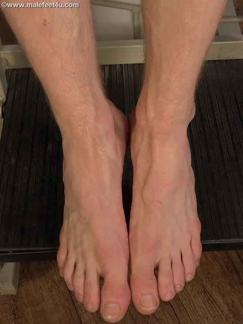 Peto Mohac’s bare soles pressed tight on dark mat, toes splayed, hairy calves framing foot-fetish focus