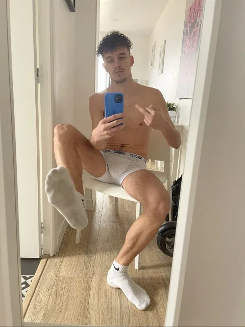Shirtless lad in white briefs and socks snaps mirror selfie, one foot kicked up for foot fetish fans