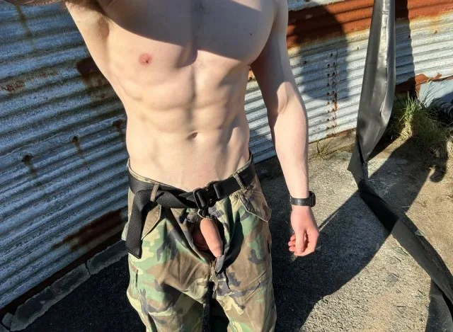 Skjult militær-stil fyr med hård pik kigger fra camo bukser udendørs
