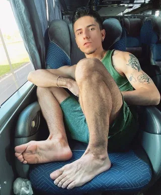 Hot barefoot lad lounging on bus seat, legs spread wide, showing hairy calves and soles