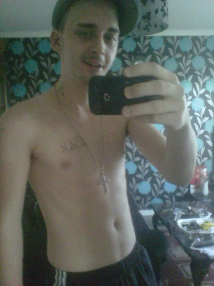 Shirtless scally lad in cap snaps mirror selfie with low-slung shorts and cross necklace