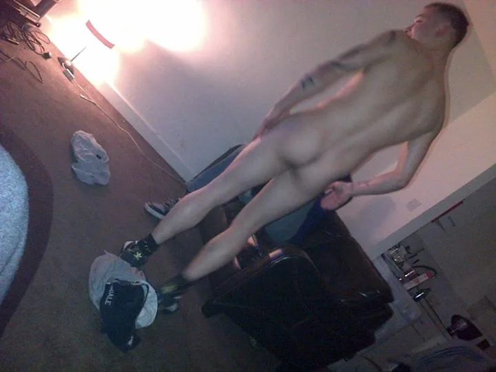 Naughty lad bends over showing off his bare ass and hard cock in messy room