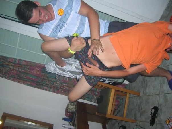 Um rapaz sorridente com tee listrada ajuda a acasalar com boxers padrões, vibe interior casual
