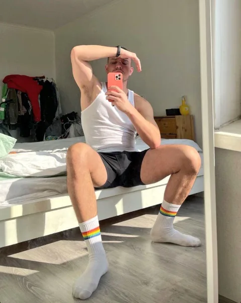Rainbow socked lad takes mirror selfie, legs spread, showing off his feet and shorts