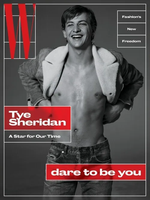 Smiling shirtless Tye Sheridan i åben jakke og jeans, selvsikker magasin cover vibe