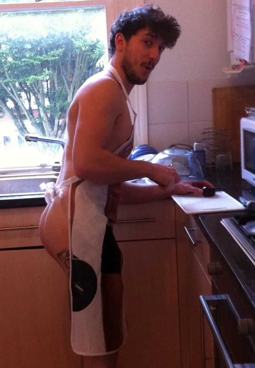 Apron-clad lad flashing his bare ass while chopping veggies in the kitchen