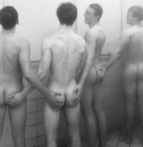 Vier nackte jungs frech im duschraum mit händen auf ihren eigenen Ärschen