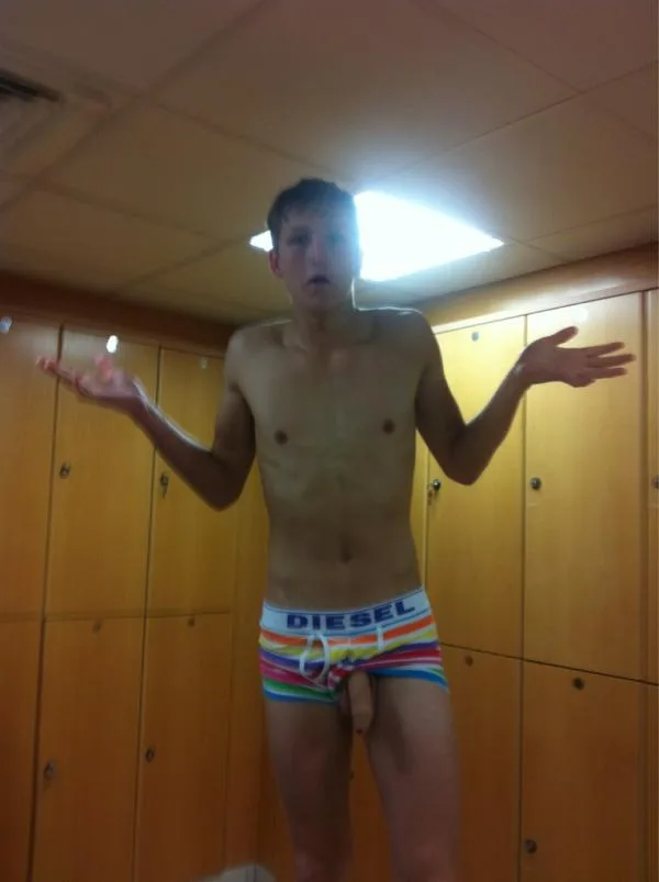 Garoto de cueca Diesel arco-íris encolhe os ombros no vestiário com o pau aparecendo