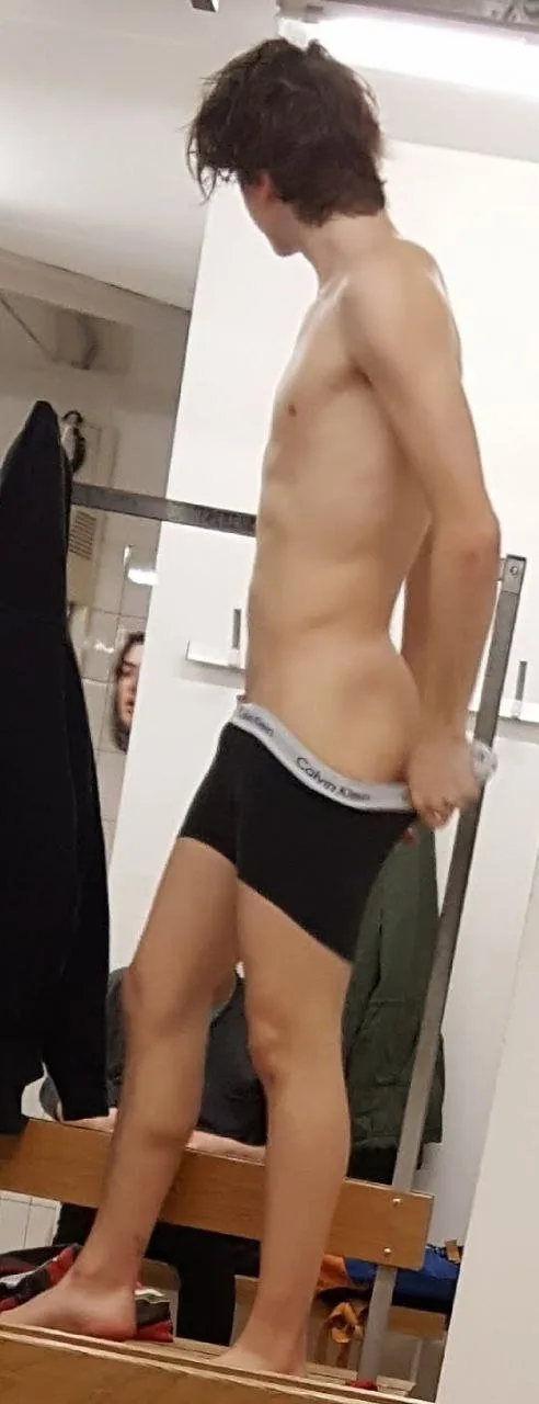Lean dreng i Calvin Klein trunks poserer shirtless med den ene hånd på hofte, side view pirring