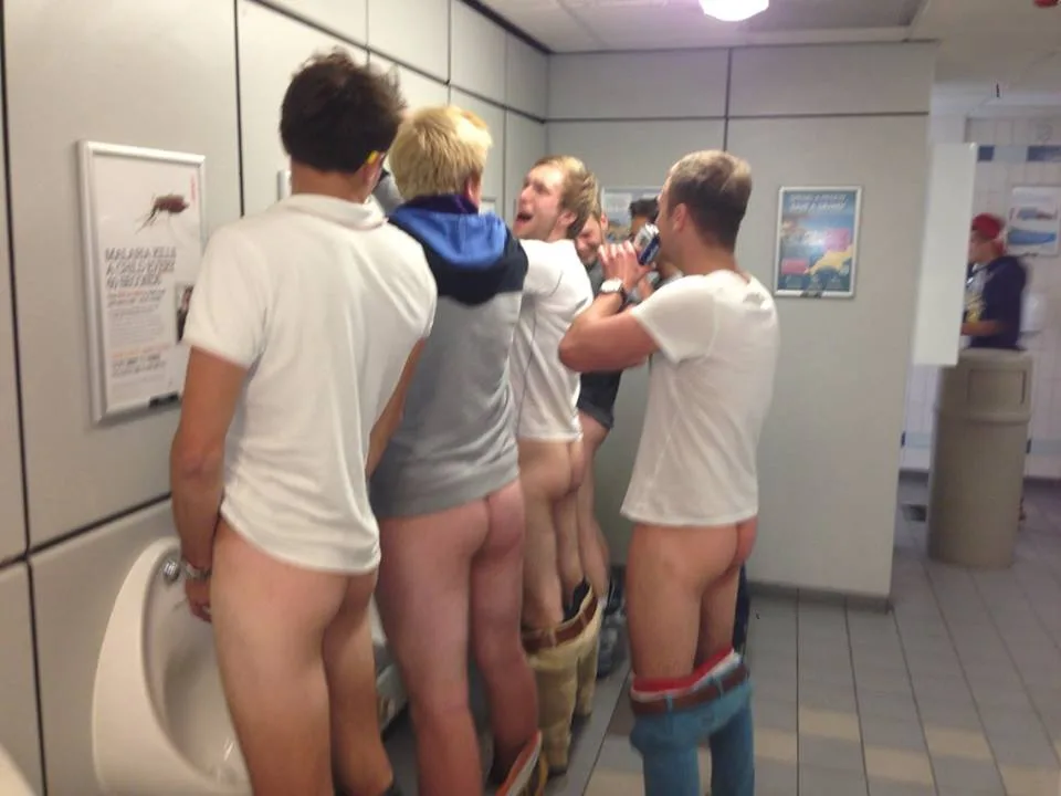 Uartige drenge blinker bare røv i en offentlig urinal linje, skjorter op, bukser ned
